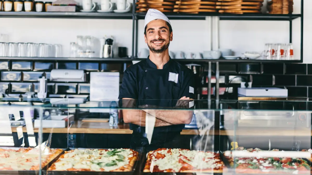 Pizza shop owner behind the counter